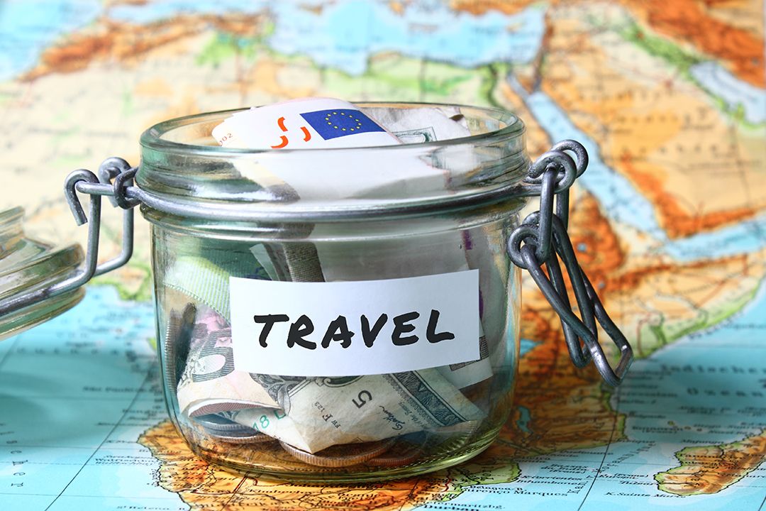 A jar labeled travel sitting on top of a map
