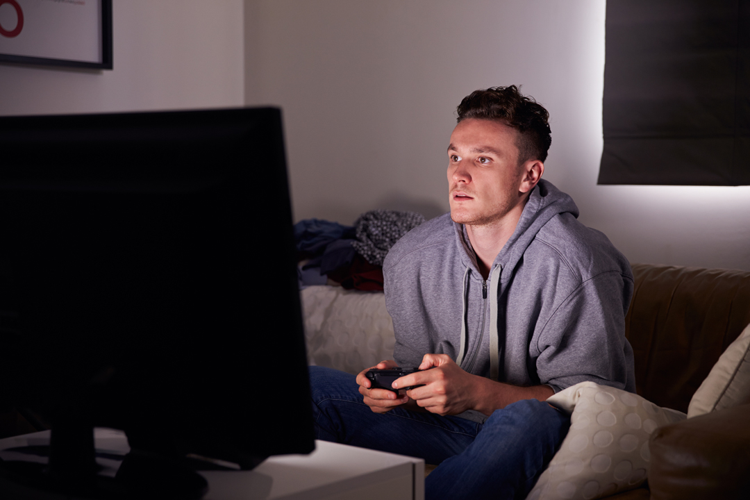 Young man in grey sweatshirt hoodie playing an online game