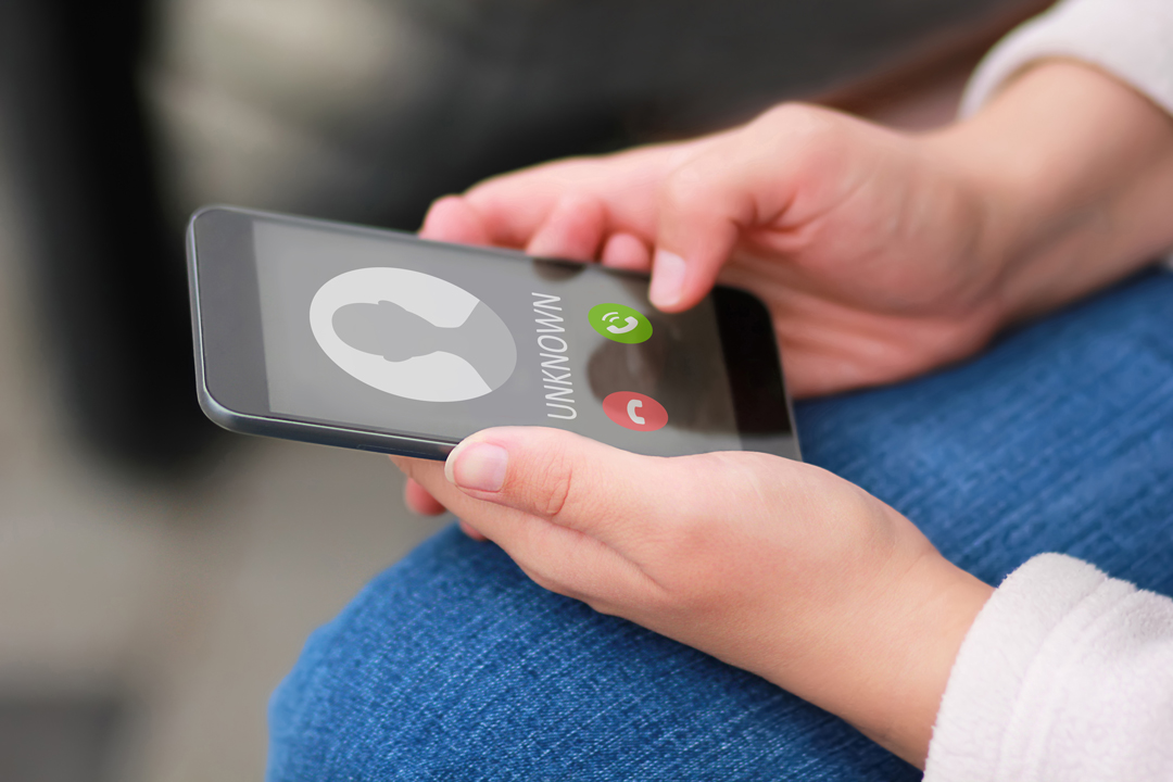 Close up of woman's hands with smartphone and unknown incoming phone call on it.