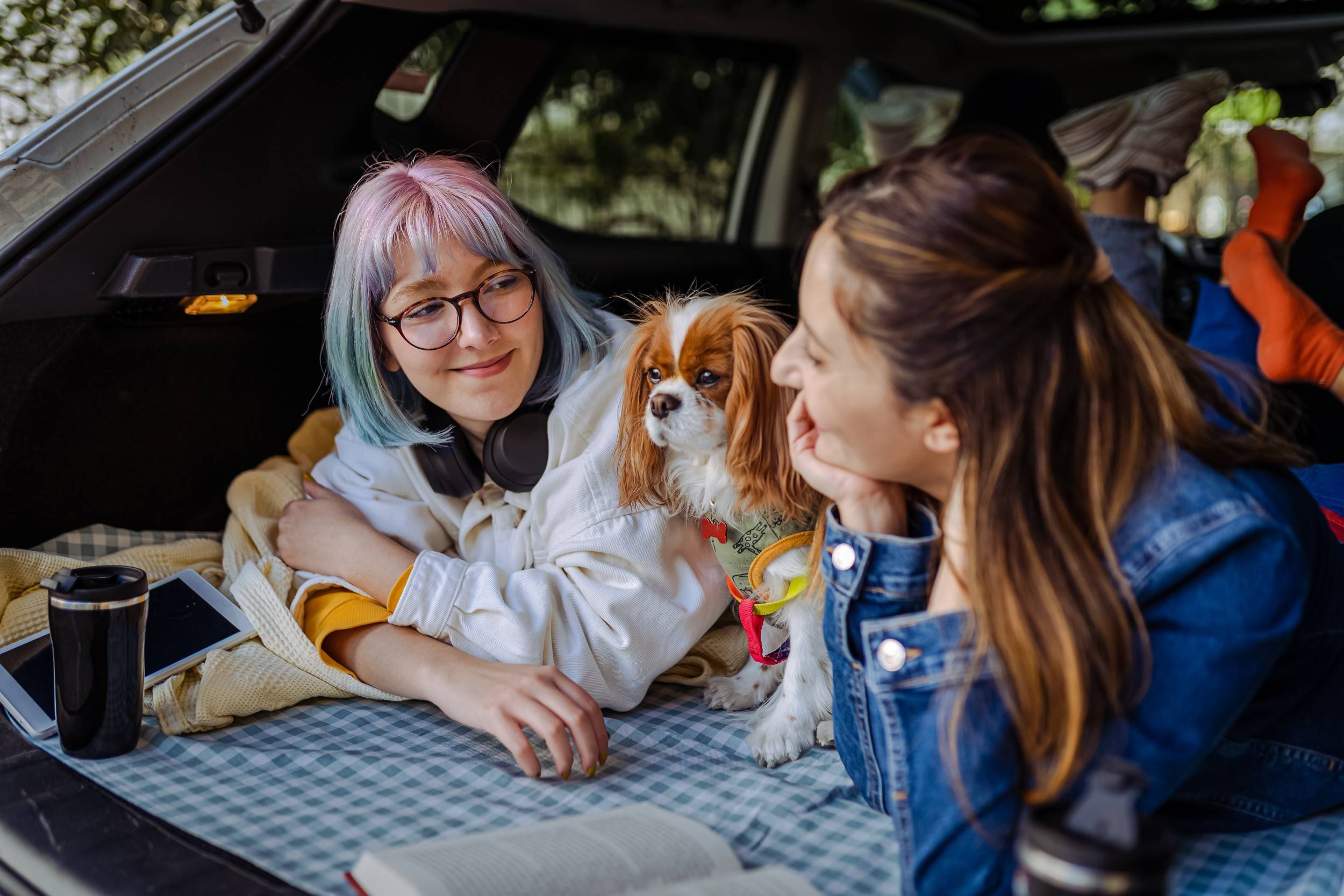 Two women pet a dog