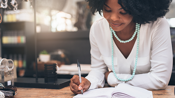 A woman writing in a notebook.