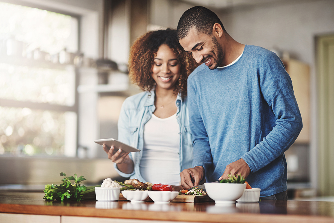 Young man and woman prepping food for dinner.