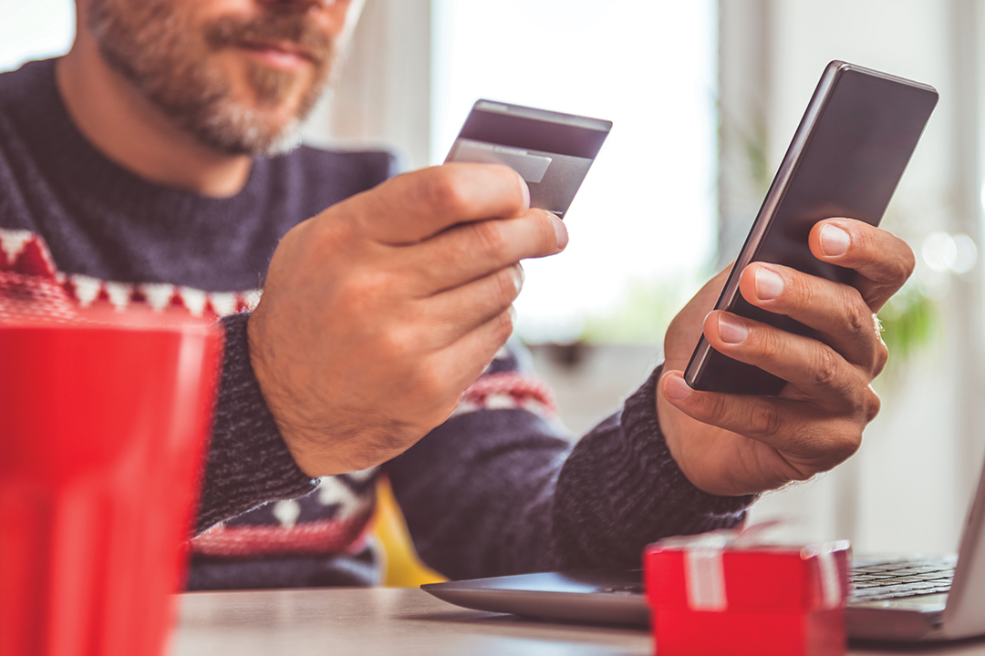 Close up of man holiday shopping from his phone