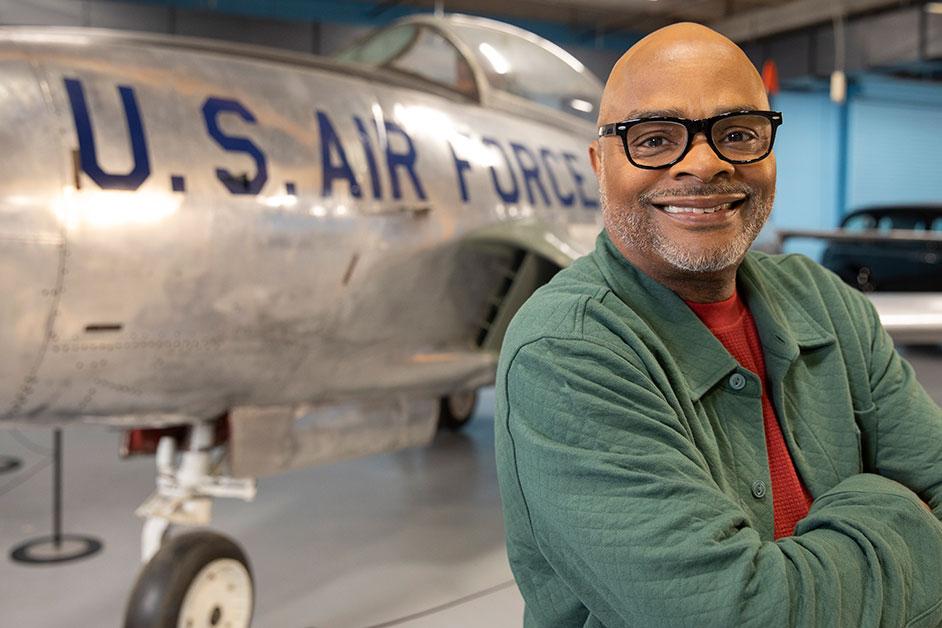 A man stands in front of an airplane