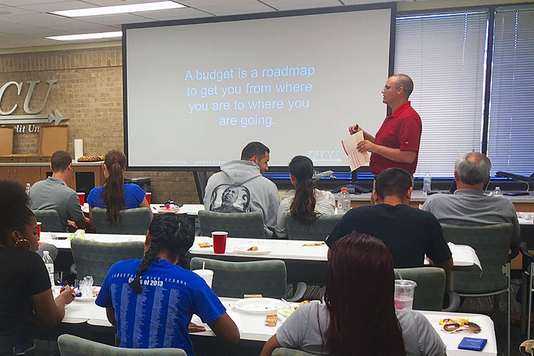 A classroom with an instructor and a projector screen