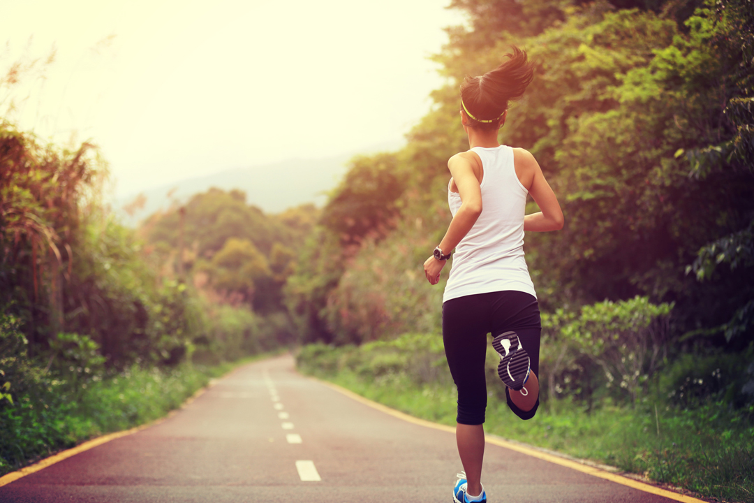 Young woman running on a country road